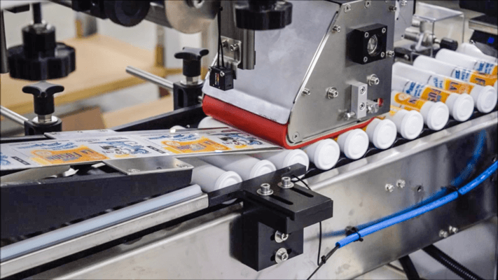 Adhesive wrap around tube labeling machine